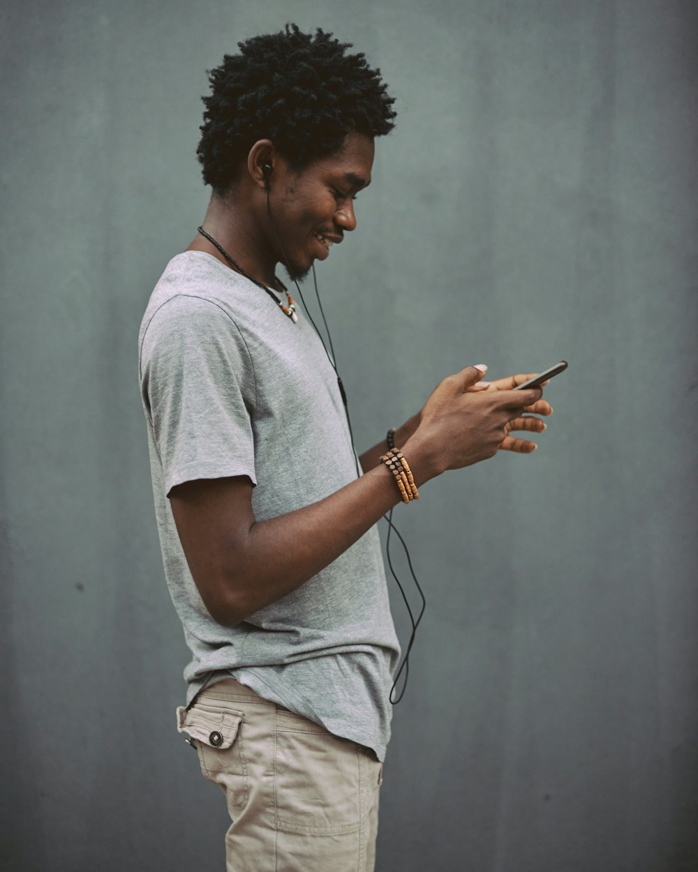 A young man smiling at something on his phone